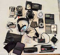 All items laid out showing variety of portable cassette players, metronome, headphones, calculators and accessories