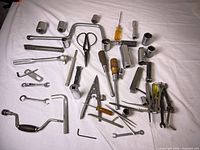 Full layout of assorted sockets, wrenches, screwdrivers, scissors, clamp and other tools on white background