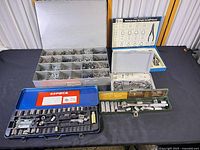 All items in lot displayed: parts organizer, retaining ring kit, Dremel tool case, blue socket set, green tool set