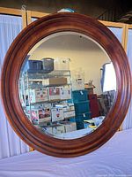 Front view showing full round mirror and wood frame