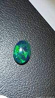 Front view of oval black opal showing play-of-color