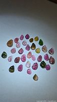 All loose tourmaline stones spread out on white background