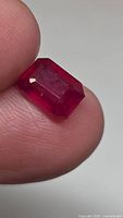Ruby held between fingers showing size and facets