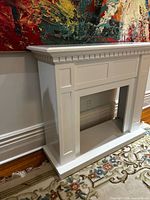 Full view of white fireplace mantel surround against wall