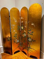 Full view of four gold panels with painted floral and bird design