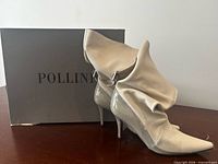 Boots standing beside Pollini box, showing overall design and fold-over shafts