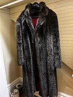 Front view of full-length faux fur coat hanging