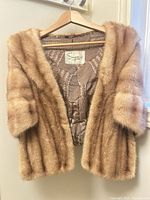 Full view of fur stole on hanger, showing exterior fur texture and shape