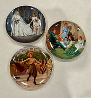 Front view of the three decorative plates showing artwork scenes