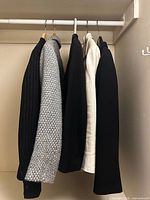 Four blazers hung on closet rod showing colors and textures