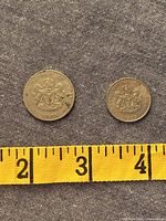 Obverse of both 1973 Nigerian coins beside measuring tape