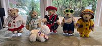 Group shot of five dressed Muffy bears on stands plus Lulu poodle on tabletop
