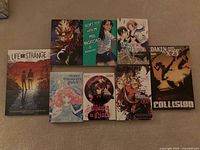 Front covers of all eight books laid out on carpet