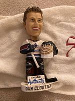 Front view of Dan Cloutier bobblehead showing jersey, mask, stick and base graphics