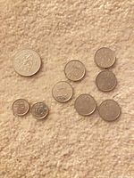 Overview of all nine Dutch coins on fabric background