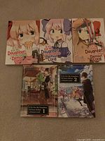 Front covers of three manga volumes and two light novels