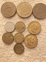 Overview of eleven assorted Costa Rica, Peru and Argentina coins on fabric background