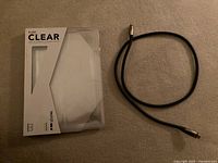Tech21 Pure Clear case in packaging beside Rocketfish HDMI cable