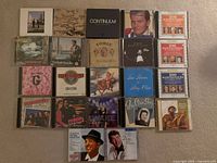 Overview of 22 assorted music CDs laid out on carpet
