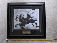 Full view of framed signed photo with measuring tape