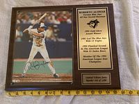 Front view of plaque showing photo, autograph, engraved plates, measuring tape for scale