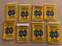 Eight sealed yellow Collegiate Collection University of Notre Dame 1st Edition trading card packs displayed face up