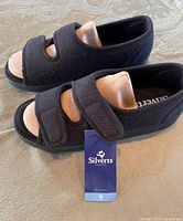 Side and top view of both sandals showing tag and hook-and-loop straps