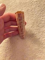Empty 50-cent paper coin roll held in hand