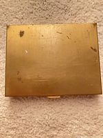 Gold-tone metal case exterior with scratches