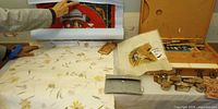 Overall lot layout showing handmade paper, rolled artwork, paint box, stamps, silk panel, pouch