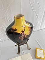 Full view of vase on stand with certificate visible