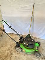 Full view of Lawn-Boy mower left side with rake leaning behind
