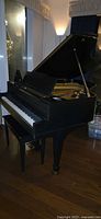 Baby grand piano front view with keyboard and bench