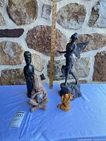 All four figurines grouped with ruler for scale