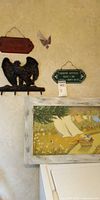 Overall view of framed print, eagle rack, plaques, butterfly