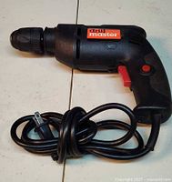 Left side view of Drill Master corded drill with coiled power cord