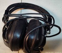 Full view of folded black Arista headphones with cable