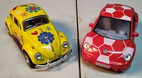 Yellow and red Volkswagen Beetle die-cast cars side by side