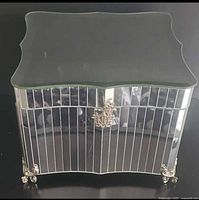 Front view showing mirrored panels, crest clasp, scroll feet