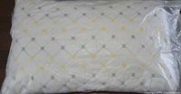 Front view of sealed pillow showing quilted diamond pattern with yellow and gray squares