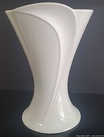 Front view showing relief curve and asymmetric rim of white porcelain vase