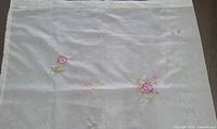 Upper section of curtain highlighting semi-sheer fabric texture and scattered floral stitches