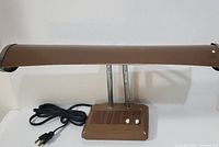 Full view of brown fluorescent desk lamp with cord