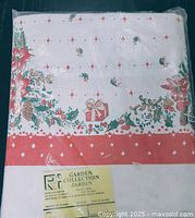 Packaged tablecloth showing folded fabric with Christmas design