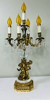 Full view of five-light gilt brass candelabra lamp with crystal prisms