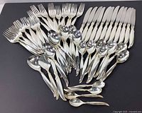 Full group of forks, knives and spoons laid out