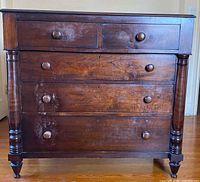 Full frontal view of dresser showing five drawers and turned legs