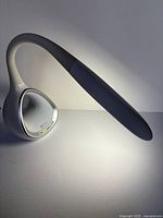 Side view of OttLite LED desk lamp illuminated