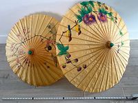 Both parasols open side by side showing size difference and painted designs