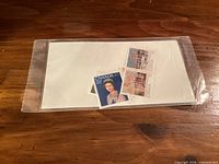 Clear plastic sleeve containing visible stamps including Queen Elizabeth II and others